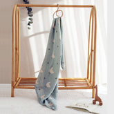 Minty Duck baby swaddle hanging on wooden nursery rack